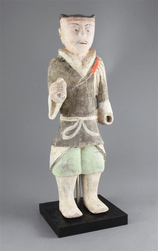 A large Chinese polychrome painted standing figure of a warrior, from Xian, Han dynasty (206BC-220AD), height 48cm, modern stand